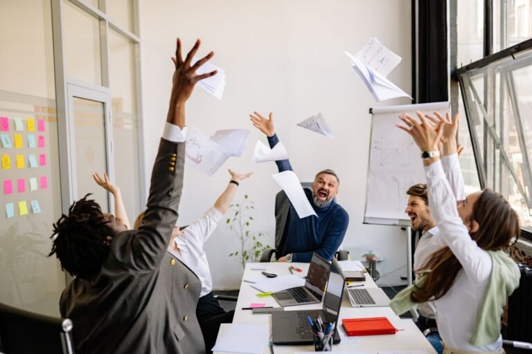 Office team celebrating with papers in the air