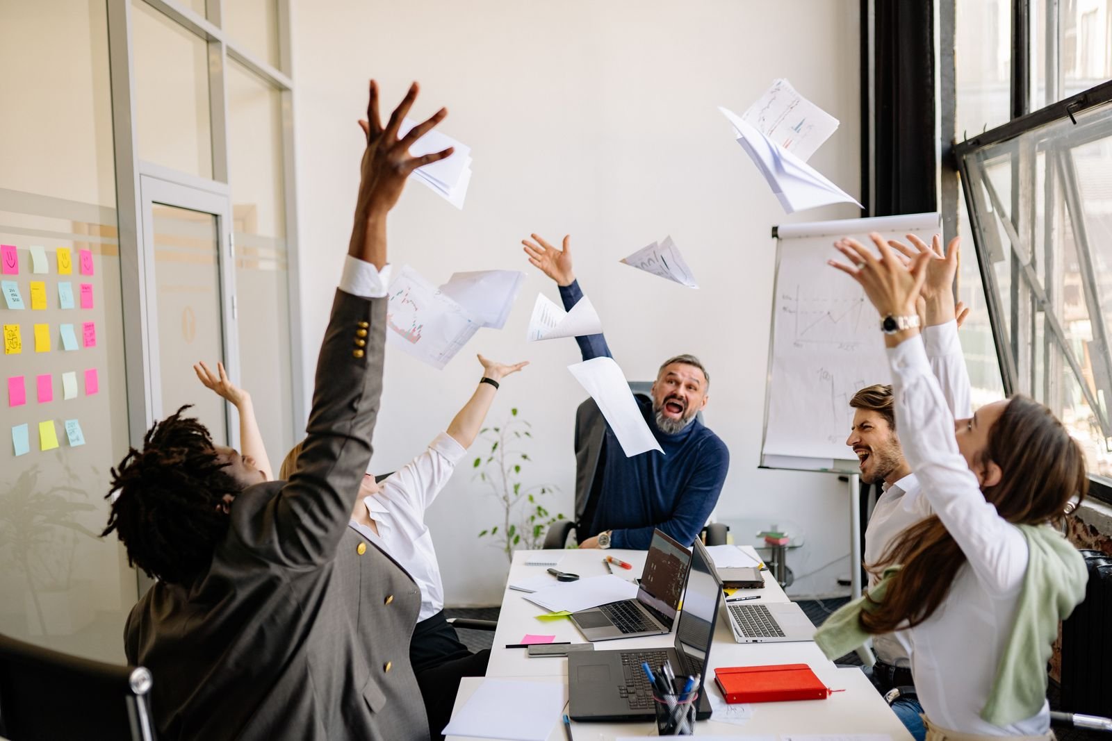 Office team celebrating with papers in the air
